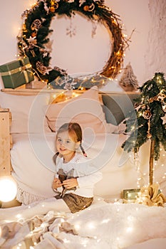 Beautiful baby girls near a Christmas tree with gifts