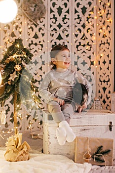 Beautiful baby girls near a Christmas tree with gifts