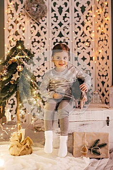 Beautiful baby girls near a Christmas tree with gifts