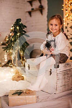 Beautiful baby girls near a Christmas tree with gifts