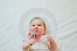 Beautiful baby holding a flower on white background