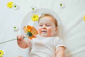 Beautiful baby holding a flower on white background