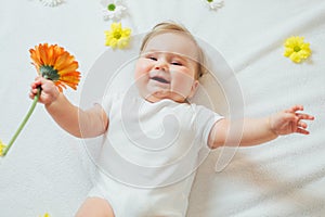Beautiful baby holding a flower on white background