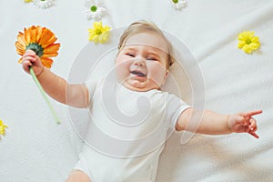 Beautiful baby holding a flower on white background