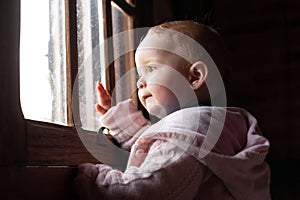 beautiful baby looking out the window with interest