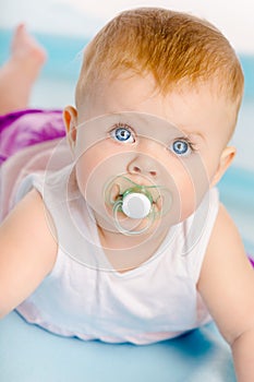 Beautiful baby with a pacifier. Close-up. Studio photo