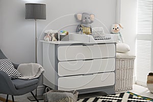 Beautiful baby room interior with changing table and rocking chair