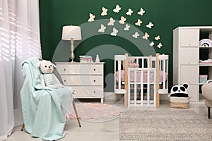 Beautiful baby room interior with stylish furniture and comfortable crib