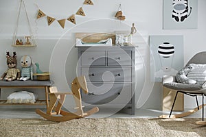 Beautiful baby room with toys, rocking chair and modern changing table