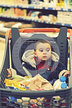 Beautiful baby in shopping cart - trolley. toned