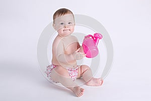 Beautiful baby sitting on the floor isolated