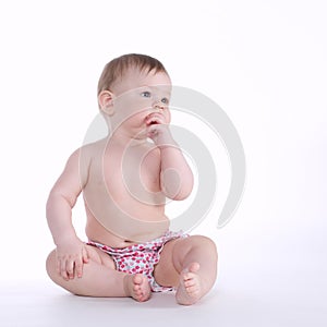 Beautiful baby sitting on the floor isolated