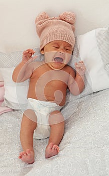 Beautiful baby with wool cap crying