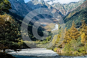 Beautiful background of the center of Kamikochi national park by snow mountains, rocks, and Azusa rivers from hills covered