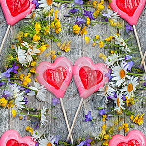 Beautiful background of flowers field of daisies and bells and two hearts made of caramel and marzipan on Valentine`s day. Copy