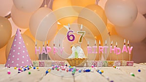 Beautiful background happy birthday number 67 with burning candles, birthday candles pink letters for sixty seven years. Festive