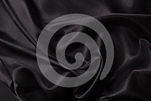 Beautiful background luxury cloth with drapery and wavy folds of black color creased smooth silk satin material texture