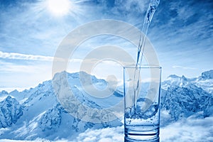 Beautiful background of pouring blue water in transparent glass