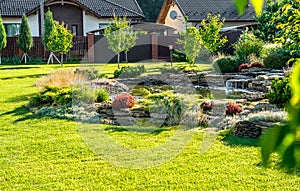 Beautiful backyard landscape design. View of colorful trees and decorative trimmed bushes rocks