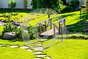 Beautiful backyard landscape design. View of colorful trees and decorative trimmed bushes rocks