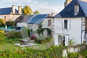 Beautiful backyard with outdoor furniture and flowers. Empty patio of old house in village, France. Rural yard.