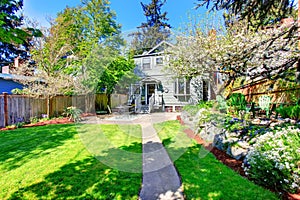 Beautiful backyard view with two patio areas and blooming trees.