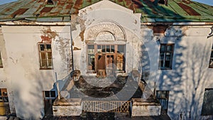 A beautiful balcony on the second floor of an old abandoned manor. White walls. Evening light.