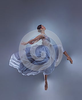 The beautiful ballerina dancing in blue long dress