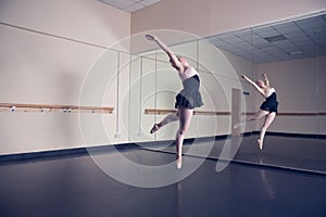 Beautiful ballerina dancing in front of mirror