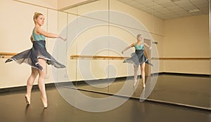 Beautiful ballerina dancing in front of mirror