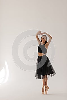 Beautiful ballerina dancing at studio in black dress, have training.