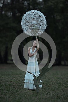 Beautiful ballerina with giant dandelions flowers