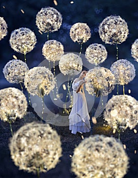 Beautiful ballerina with giant dandelions with lights