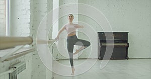 Beautiful ballerina rehearsing in ballet studio