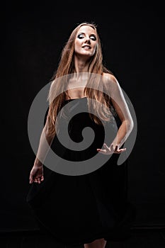 Beautiful ballet dancer posing on black isolated