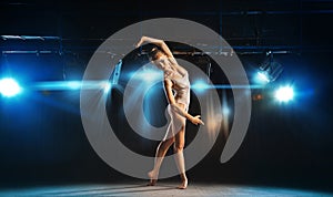 Beautiful ballet dancer posing on stage in theater