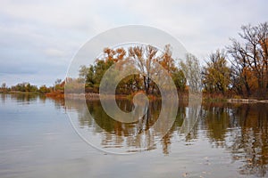 The beautiful bank of the Dnipro river with yellow, green, red trees, bushes with a pleasant autumn nature of the city of Kamiansk