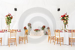 Beautiful banquet hall under a tent for a wedding reception. Interior of a wedding tent decoration ready for guests