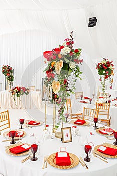 Beautiful banquet hall under a tent for a wedding reception. Interior of a wedding tent decoration ready for guests