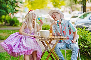 Beautiful barbie girl and boyfriend ken in cafe with a huge cup of coffee