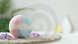 Beautiful bath bomb on wicker mat indoors, space for text