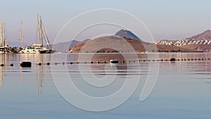 Beautiful bay with calm blue sea, sailboats, islands and mountains