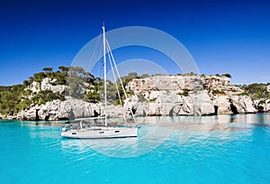 Beautiful bay in Mediterranean sea with sailing boat, Menorca island, Spain. Yachting, travel and active lifestyle concept