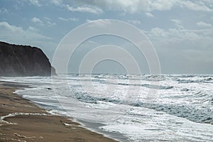 Beautiful beach on the Atlantic coast near Colares, Portugal, located at the foot of the Sierra de Sintra mountains photo