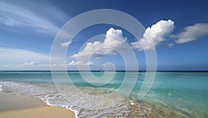 A beautiful beach with a blue ocean and white clouds in the sky.