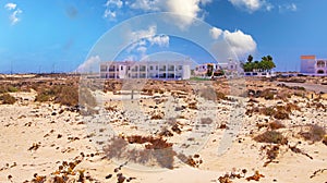 Beautiful beach coast landscape, sand dunes, colorful seaside vacation homes cottages and hotel building, blue summer sky - El