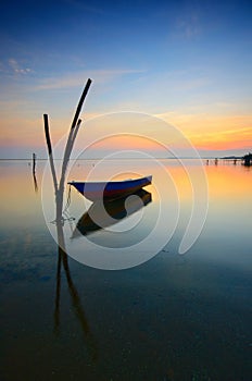 beautiful beach with fisherman boat during sunrise at Jubakar Beach Kelantan, malaysia. soft focus due to long exposure.