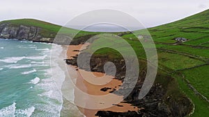 Beautiful beach and green fields at the coast of Dingle Peninsula in Ireland