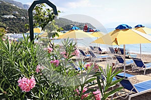 Beautiful beach in Ipsos on Corfu, tourists enjoying a nice summer day at the beach. Greece