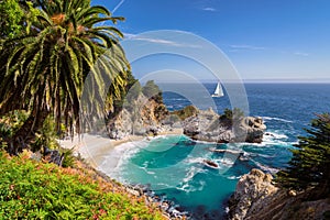 Beautiful beach with palm trees and the white yacht on the horizon